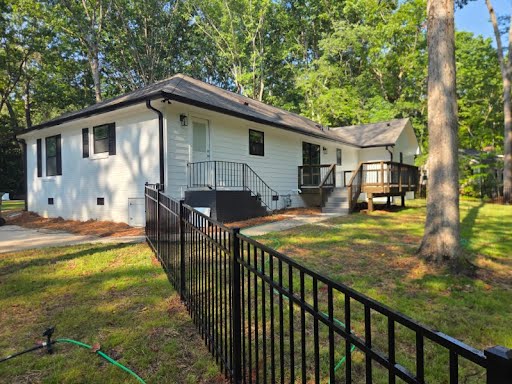 Finished rental house exterior with painted brick, new roof, and the master bathroom addition at the rear